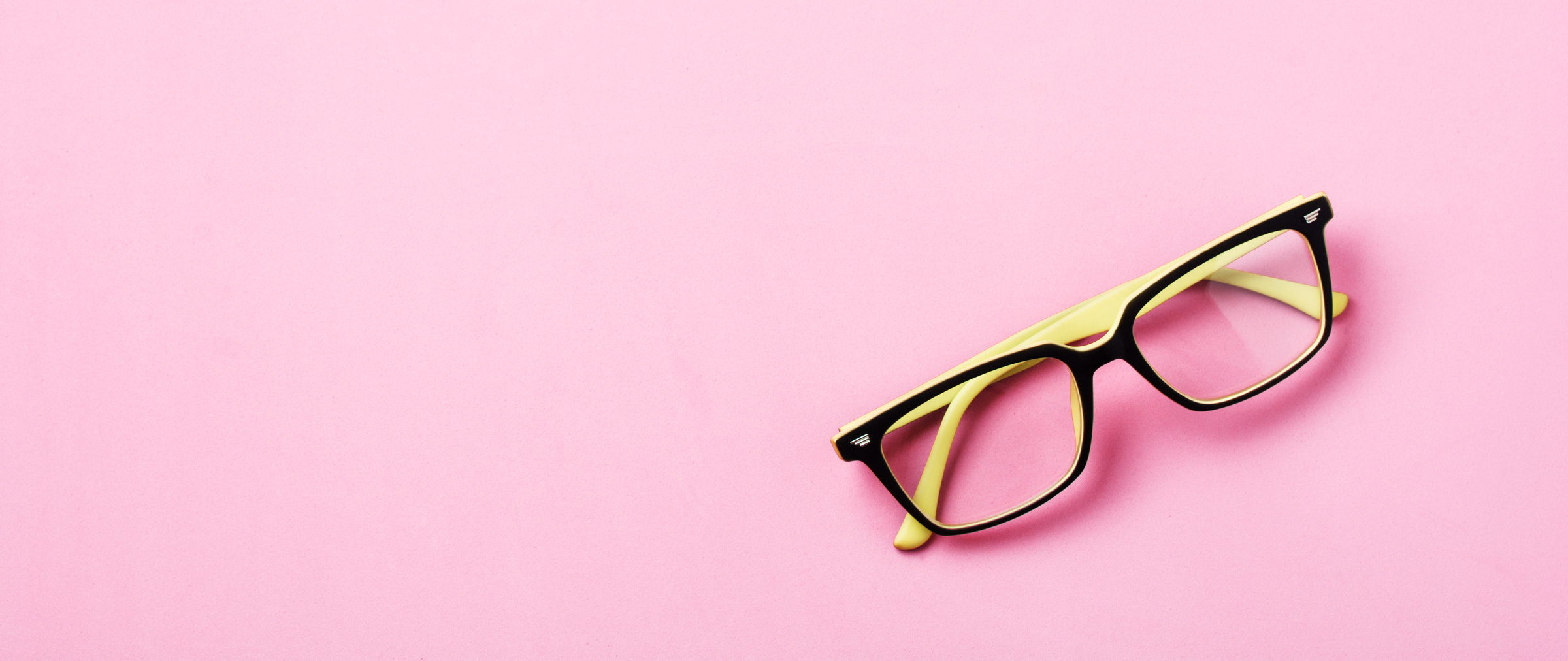 Modern Spectacles Eye Glass or Eyeglasses Isolated on Pink Background. Top View. Banner. Mock up.